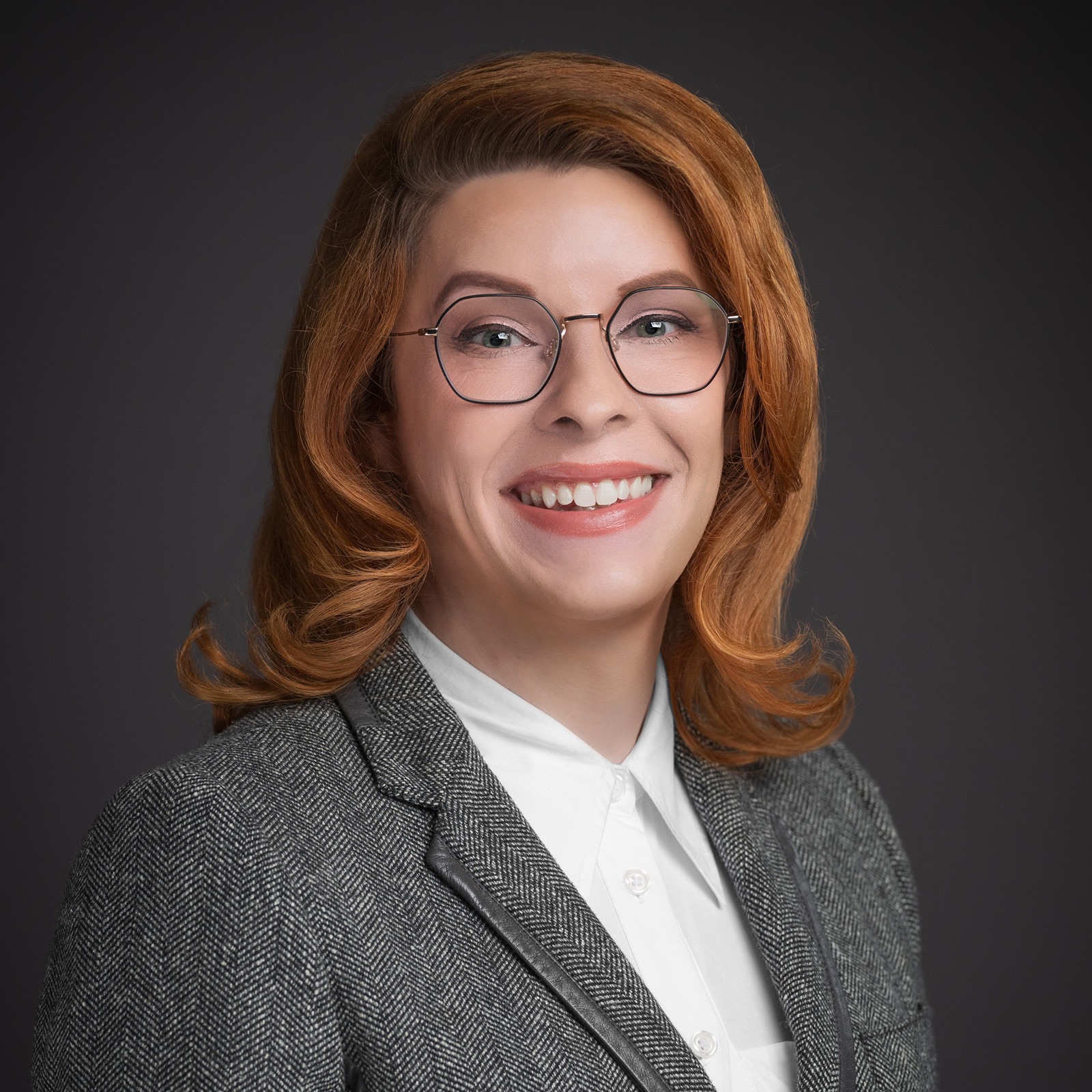 Danni Askini professional portrait in gray blazer